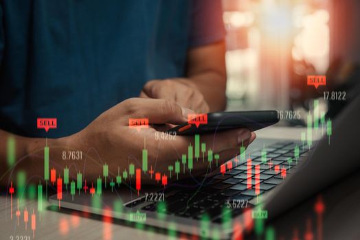 Stock market trading investments exchange graph on screen.man trader investor analyst using mobile phone data index chart on smartphone.