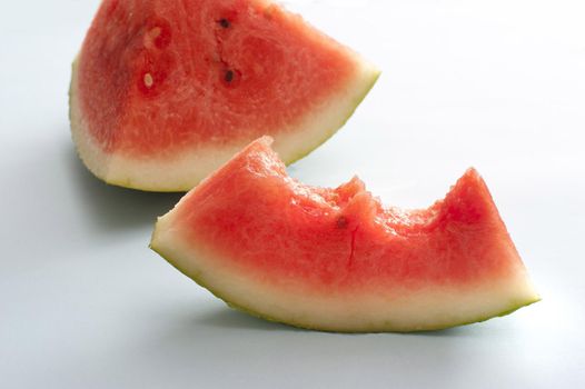 Half eaten slice of fresh juicy watermelon viewed low angle standing upright for a tasty refreshing summer treat