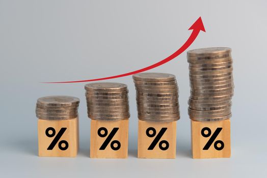 Business finance investments economy stack coin inflation and arrow red with wood cube percentage on desk.