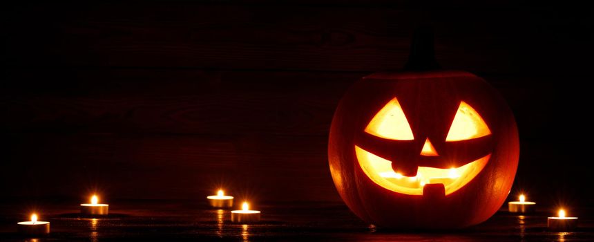 Halloween Jack O Lantern pumpkin and burning candles traditional decoration