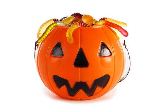 Sweets gummy worms candies in Halloween bag basket jack o lantern pumpkin isolated on white background