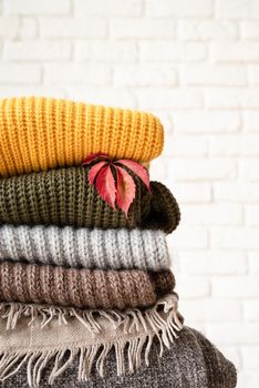 Hello fall. Cozy warm image. Stack of colorful autumn warm sweaters