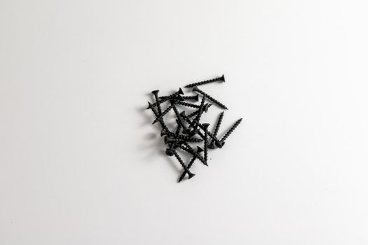 Heap of black screws on a white isolated background