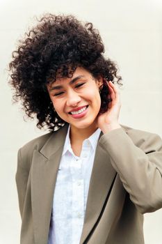 portrait of a stylish business woman smiles happy touching her curly hair, concept of success and youth