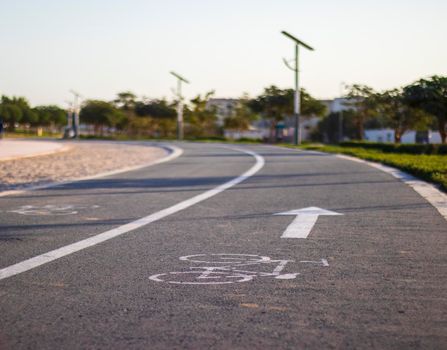Jogging and cycling tracks in Al Warqa park, Dubai, UAE early in the morning. Lamp post powered by solar panels can be seen in the picture.