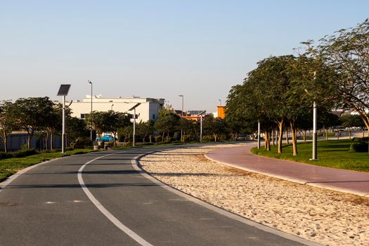 Jogging and cycling tracks in Al Warqa park, Dubai, UAE early in the morning. Lamp post powered by solar panels can be seen in the picture. Outdoors
