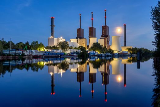 A power station in Berlin at night with a perfect reflection in the water