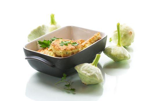 vegetable fried squash and zucchini cutlets in a ceramic form isolated on a white background
