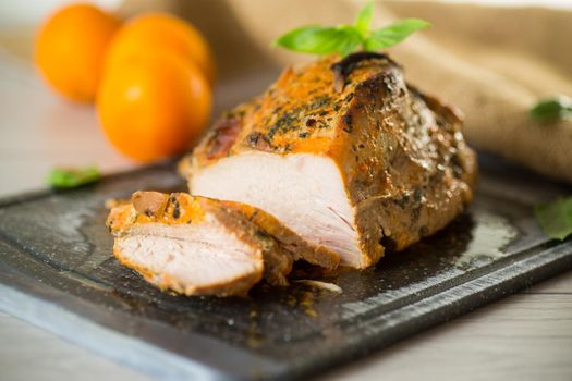 Baked sirloin turkey meat homemade with spices, on a wooden table.