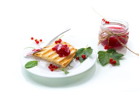fried bread croutons for breakfast with redcurrant jam in a plate with berries isolated on white background
