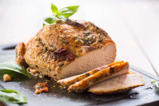 Baked sirloin turkey meat homemade with spices, on a wooden table.