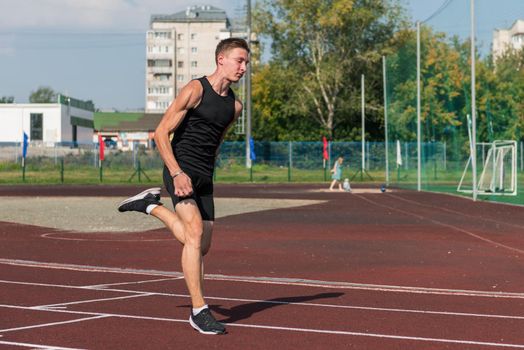 Young woman running on the running track at the stadium outdoors
