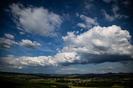 Beauty cloud against a blue sky background. Sky slouds. Blue sky with cloudy weather, nature cloud over the landskape. Over the land white clouds, blue sky and sun. High quality photo