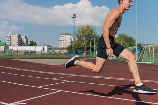 Young woman running on the running track at the stadium outdoors