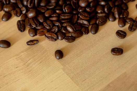 Brown Roasted Coffee Beans Closeup On Wooden Background. High quality photo