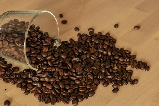Glass of coffee beans on a wooden table. High quality photo