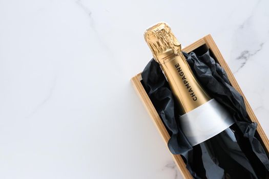 Wedding celebration, lifestyle and luxury present concept - A champagne bottle and a gift box on marble