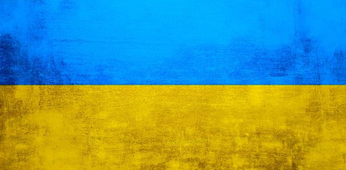 The wall is in the colors of the Ukrainian national flag - blue and yellow. Abstract texture background of concrete stone wall. Ukrainian flag on a grunge wall in connection with the war with Russia