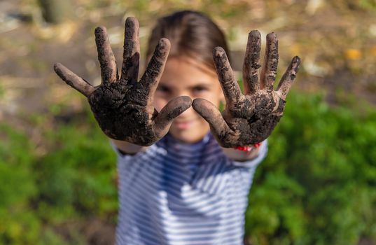 The child holds soil in the garden. Selective focus. kid.