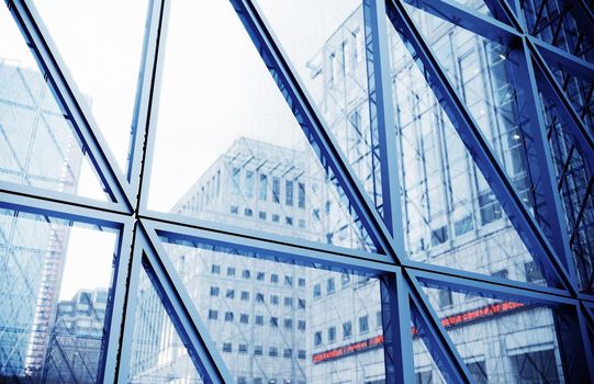 Glass building with city reflection in window. Transparent glass wall of office building. Modern office building with glass facade on a clear sky background. 3d Rendering. 3D Illustration.