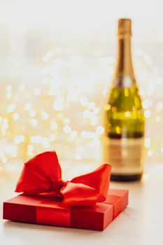 Romantic celebration, lifestyle and luxury present concept - The bottle of champagne and holiday gift box