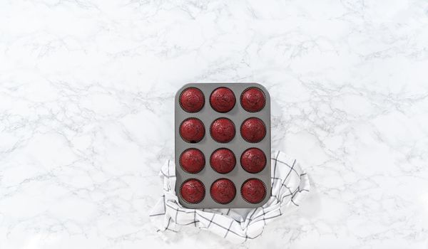 Flat lay. Cooling freshly baked red velvet cupcakes on a kitchen counter.