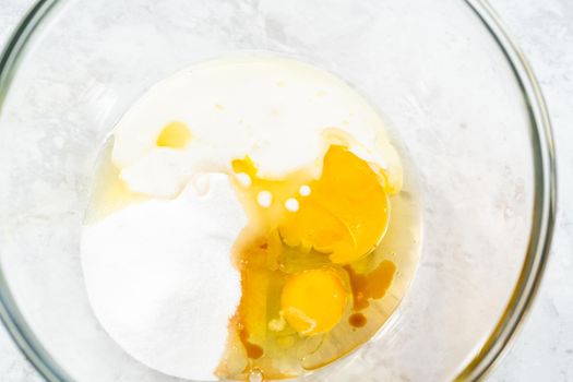 Mixing ingredients in a glass mixing bowl to bake s'mores cupcakes.