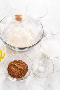 Ingredients in a glass mixing bowls to bake chocolate strawberry cupcakes.