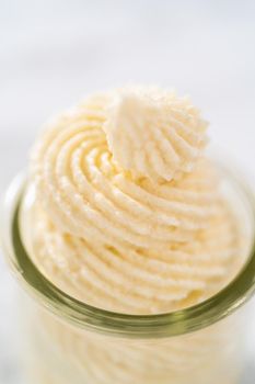 White chocolate ganache frosting in a small glass mason jar.