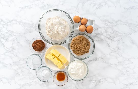 Flat lay. Measured ingredients in glass mixing bowls to bake red velvet cupcakes with white chocolate ganache frosting.