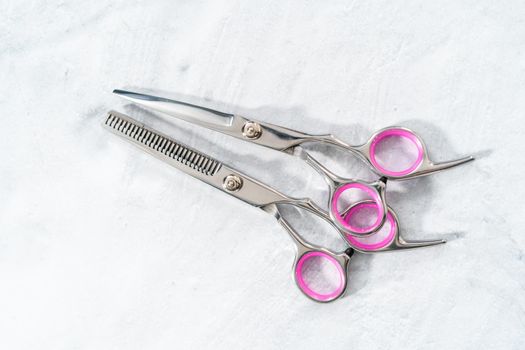 New barber pink scissors on a gray background.