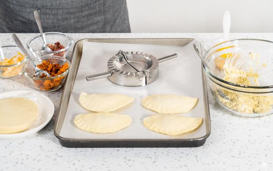 Filling empanada dough with egg filling to make breakfast empanadas with eggs and sweet potato.