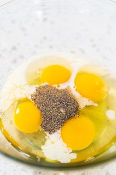 Mixing ingredients in a glass mixing bowl to prepare filling for breakfast empanadas with eggs and sweet potato.