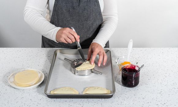 Filling empanada dough with blueberry pie filling to make sweet empanadas with blueberries.
