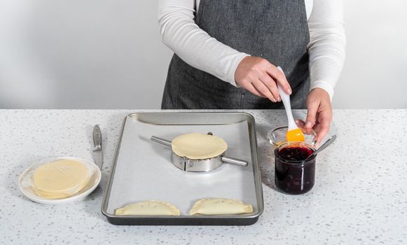 Filling empanada dough with blueberry pie filling to make sweet empanadas with blueberries.