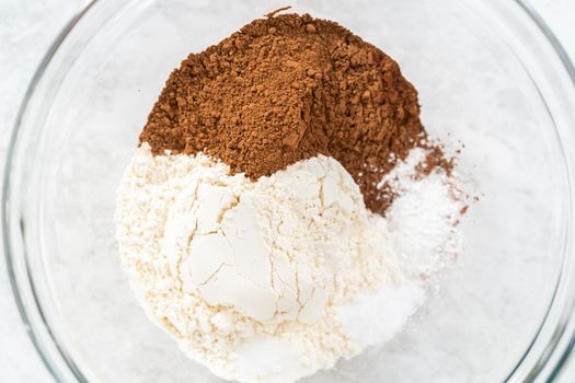 Mixing ingredients in a glass mixing bowl to bake s'mores cupcakes.