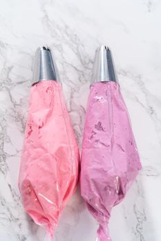 Ombre pink buttercream frosting in a piping bag with a jumbo metal piping tip.