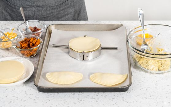 Filling empanada dough with egg filling to make breakfast empanadas with eggs and sweet potato.