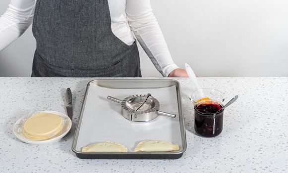 Filling empanada dough with blueberry pie filling to make sweet empanadas with blueberries.