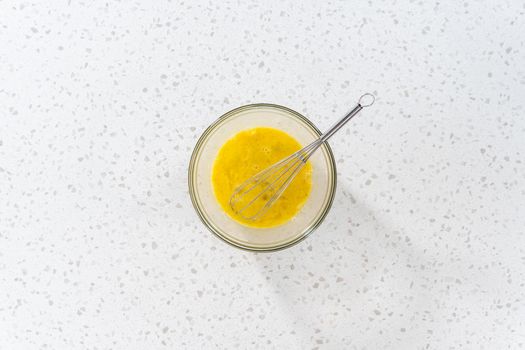 Flat lay. Mixing ingredients in a glass mixing bowl to prepare filling for breakfast empanadas with eggs and sweet potato.