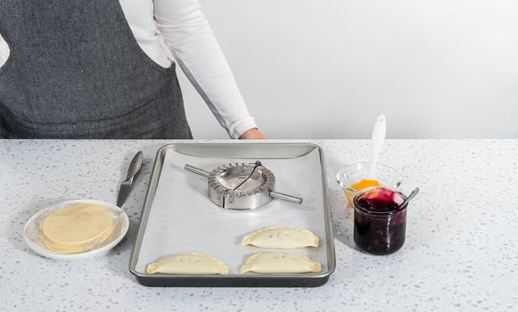 Filling empanada dough with blueberry pie filling to make sweet empanadas with blueberries.