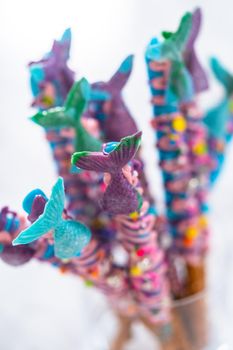 Mermaid chocolate pretzel rods drizzled with pink and purple chocolate and covered with sprinkles.