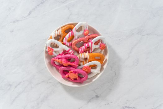 Flat lay. Gourmet chocolate-covered pretzel twists with seashell-shaped chocolates.