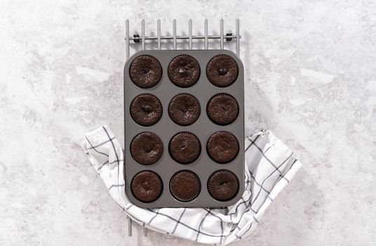 Flat lay. Cooling freshly baked chocolate cupcakes on the counter.