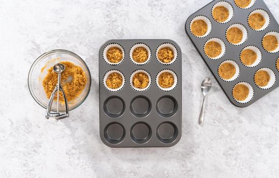 Flat lay. Filling cupcake liners with graham crackers to baking s'mores cupcakes.