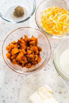 Measured ingredients in glass mixing bowls to make breakfast empanadas with eggs and sweet potato.