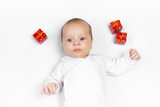 Baby and New Year 's gifts . An article about the New Year . Choosing a children 's gift . Baby on a white background