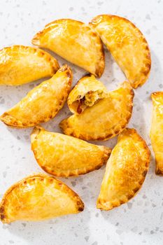 Freshly baked breakfast empanadas with eggs and sweet potato on the kitchen counter.