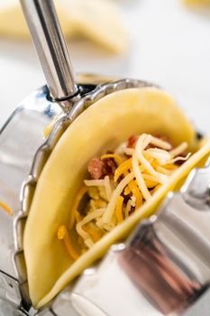 Filling empanada dough with egg filling to make breakfast empanadas with eggs and sweet potato.