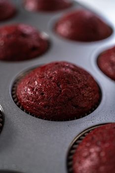 Cooling freshly baked red velvet cupcakes on a kitchen counter.